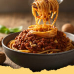 vegane bolognese aus linsen und walnuessen - Eine Nahaufnahme einer reichhaltigen veganen Bolognese aus Linsen und Walnüssen, serviert auf frischer Pasta, garniert mit Basilikum.