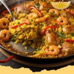 einfache spanische haehnchen paella in der pfanne - Eine köstliche, goldbraune einfache spanische Hähnchen Paella in der Pfanne, garniert mit Zitronenspalten und Petersilie, servierbereit.