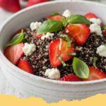 fruehlings quinoa salat mit erdbeeren und ziegenkaese - Ein bunter Frühlings Quinoa Salat mit Erdbeeren, Ziegenkäse und frischen Kräutern in einer großen Schüssel.