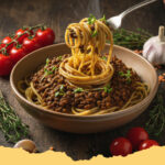 vegane linsen bolognese mit sojahack - Eine appetitliche Schale vegane Linsen Bolognese mit Sojahack auf Spaghetti, garniert mit frischen Kräutern.