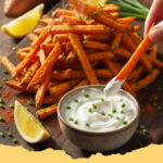 knusprige ofen suesskartoffel pommes mit dip - Teller mit goldbraunen knusprigen Ofen-Süßkartoffel-Pommes und einem kleinen Schälchen cremigem Kräuter-Dip