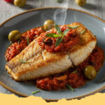 mediterrane seelachsfilets mit tomaten oliven sauce - Mediterrane Seelachsfilets mit Tomaten-Oliven-Sauce auf einem Teller, garniert mit frischen Kräutern