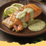 gebackener lachs mit frischer dill sauce - Gebackener Lachs mit frischer Dill-Sauce auf einem Teller mit Zitrone und Dill garniert.