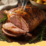 oster essen rezepte - Saftiger Lammbraten mit Rosmarin und Knoblauch auf einem Servierteller mit Beilagen