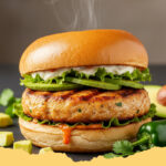 saftiger halal haehnchen burger mit avocado - Ein saftiger Halal Hähnchen Burger mit Avocado, aufgeschnitten mit cremiger Guacamole und frischem Salat.