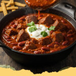 schneller rindfleisch chili con carne - Ein dampfendes Schälchen schnelles Rindfleisch Chili con Carne, garniert mit frischem Koriander und einem Klecks Sour Cream.