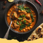 wuerziges lammcurry mit kichererbsen und spinat - Ein dampfendes, würziges Lammcurry mit Kichererbsen und Spinat, garniert mit frischem Koriander, serviert in einer tiefen Schale mit Basmatireis im Hintergrund.