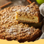 einfacher apfelkuchen mit streuseln - Ein Anschnitt eines einfachen Apfelkuchens mit knusprigen Streuseln, gefüllt mit saftigen Äpfeln, auf einem Kuchenteller.